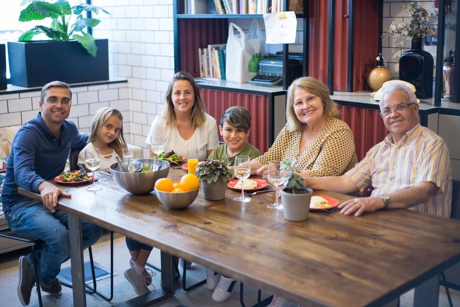 Three generations sitting around a dining table together at home - the family reunification and partner routes are what keep tables like this full.